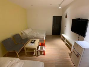 a living room with a couch and a tv at Chill Place in Zhudong