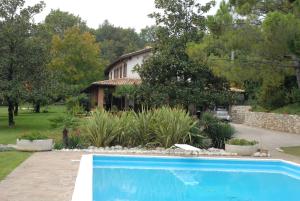 a swimming pool in front of a house at B&B Soiano Del Lago in Soiano del Lago