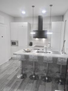 uma cozinha com um lavatório e um balcão com bancos em Apartamento estilo nórdico en Malasaña (Madrid Centro) em Madrid