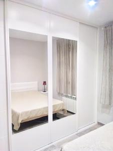 1 dormitorio con armario blanco y cama. en Apartamento estilo nórdico en Malasaña (Madrid Centro), en Madrid