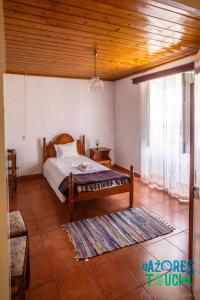 una camera da letto con un letto e una grande finestra di Quinta de Sao Carlos ad Angra do Heroísmo