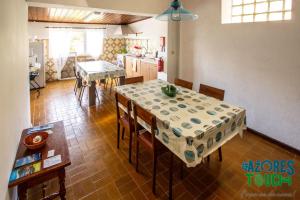 cocina y comedor con mesa y sillas en Quinta de Sao Carlos, en Angra do Heroísmo