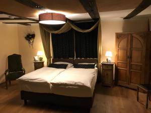 a bedroom with a large bed and a large window at McMüller's Kemenate Fulda in Fulda
