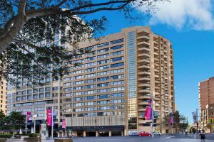 a tall building with pink flags in front of it at Cosmopolitan apartment at College St in Sydney