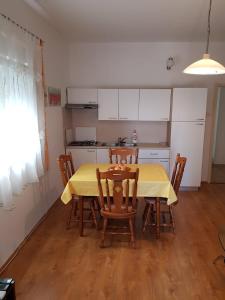 kuchnia z żółtym stołem i krzesłami w pokoju w obiekcie Apartment Olives w mieście Zadar
