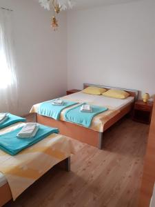 2 łóżka w sypialni z niebieską i żółtą pościelą w obiekcie Apartment Olives w mieście Zadar