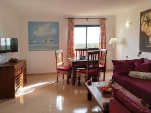 sala de estar con mesa y sofá en Apartment Gardenia, Oasis Tamarindo, en Corralejo