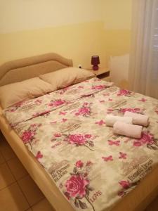 Una cama con dos toallas y flores. en Djukic apartments en Budva