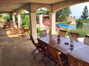 a patio with a table and chairs and a pool at Villa Olea in Koromačno