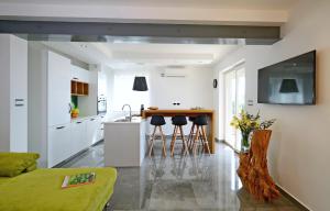 a kitchen and living room with a counter and stools at Villa Olea in Koromačno