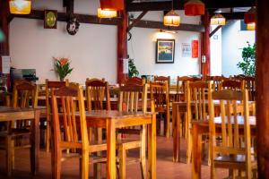 an empty restaurant with wooden tables and chairs at La Casa Resort in Phú Quốc
