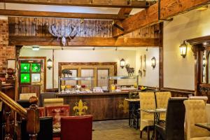 a restaurant with a bar with chairs and tables at Rogerthorpe Manor Hotel in Pontefract