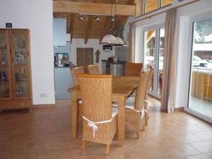 una sala da pranzo con tavolo e sedie in legno di Ferienwohnung Iselerblick a Bad Hindelang