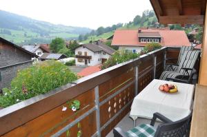 a table with a bowl of fruit on a balcony at Beim Jokelar in Bad Hindelang