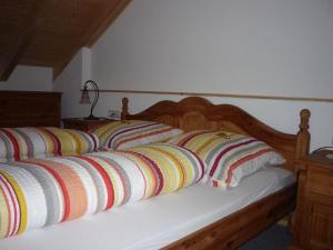 un letto con cuscini a righe colorate di Ferienwohnung Iselerblick a Bad Hindelang
