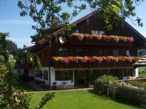 a building with flowers on the balconies on it at Ferienhof Beim Kemptar in Bad Hindelang