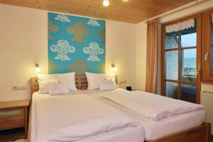 a bedroom with a large white bed with a blue wall at Haus Sonnenruh in Bad Hindelang