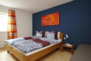 1 dormitorio con 1 cama con pared azul en Ferienwohnung "Beim Schofer" en Bad Hindelang