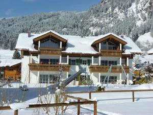 una casa en la nieve con un tobogán en Ferienwohnung "Beim Schofer" en Bad Hindelang