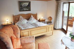 a bedroom with a wooden bed and a couch at Beim Jokelar in Bad Hindelang