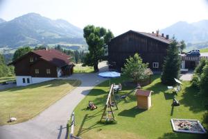 a group of people sitting on the grass near a barn at Haus Edelweiß in Bad Hindelang