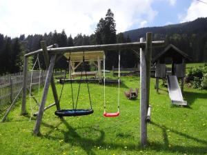 um parque infantil com baloiços num campo de relva em Ferienhof Beim Kemptar em Bad Hindelang