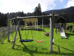 a playground with swings in a field of grass at Ferienhof Beim Kemptar in Bad Hindelang