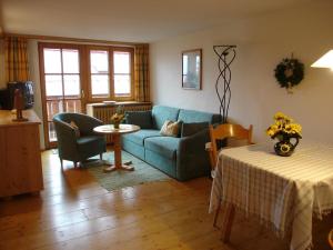a living room with a blue couch and a table at Haus Geiger in Bad Hindelang