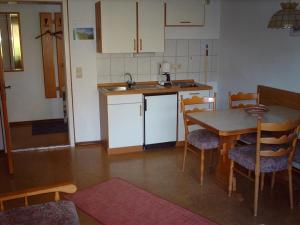 a kitchen with a table and chairs in a room at Haus Marianne in Oberjoch