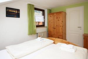 a bedroom with two white beds and a window at Ferienwohnung Pinocchio in Bad Hindelang