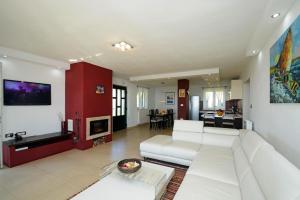 a large living room with a white couch and a living room with at Villa Olea in Koromačno