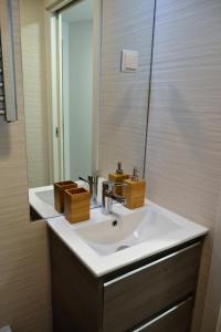 un bagno con un lavandino bianco e uno specchio di Modern Cozy Studio - Portas Do Sol a Lisbona