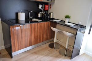 una cucina con bancone, lavandino e 2 sgabelli di Modern Cozy Studio - Portas Do Sol a Lisbona Altre 11 foto