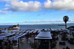 un gruppo di tavoli e ombrelloni accanto all'acqua di Modern Cozy Studio - Portas Do Sol a Lisbona