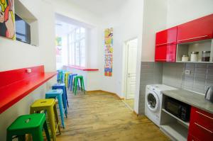 a kitchen with a washing machine and colorful stools at Pop Art Hostel in Lviv