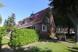 a brick house with a hedge in front of it at FeWo Ostsee Ahoi in Timmendorfer Strand