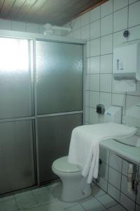 a bathroom with a shower and a toilet and a sink at Hotel Vale Verde in Porto Seguro