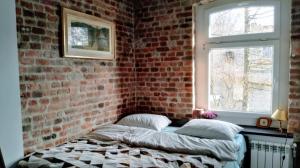 a bedroom with a brick wall and a bed with pillows at Familuks - Apartementy Katowice Ligota in Katowice