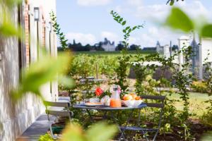 a table with drinks and fruit on a patio at La Maison des Vignes - Domaine de la Soucherie in Beaulieu-sur-Layon +2 photos