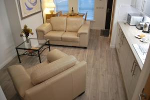 een woonkamer met een bank, stoelen en een tafel bij Gallowgate Square Apartments in Largs