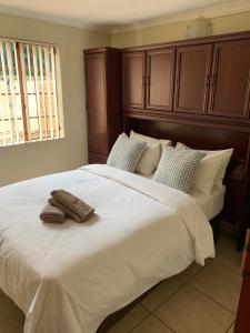 una camera da letto con un grande letto bianco con due asciugamani di Villa de la Rosa Klerksdorp a Klerksdorp