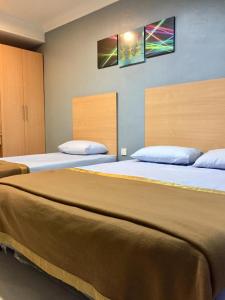two beds in a room with two bedsvisor at Hotel Budget Lestari in Kota Bharu