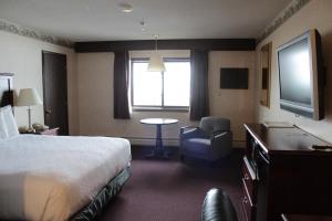 a hotel room with a bed and a table and a television at Shiretown Inn & Suites in Houlton