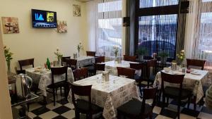 a dining room with tables and chairs and a tv at Hotel Berliner Hof in Düsseldorf