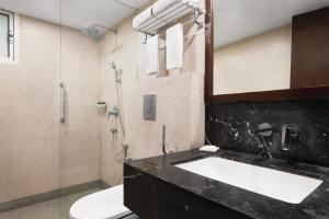 a bathroom with a sink and a shower at Howard Johnson by Wyndham, Kolkata Airport in Kolkata