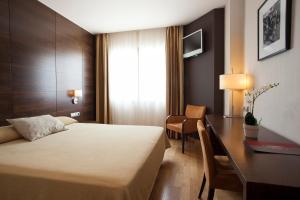 a hotel room with a bed and a desk at Hotel FC Villalba in Collado-Villalba +39 photos