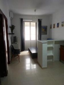 een woonkamer met een wit bureau en een raam bij Apartamento Feduchy in Cádiz
