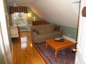a living room with a couch and a coffee table at Bakers Chest B&B in Truro