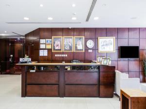 a lobby with a reception desk and a clock at Open Hotel Alolaya in Al Khobar
