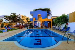 a large swimming pool in front of a building at Eltina Apartments in Malia